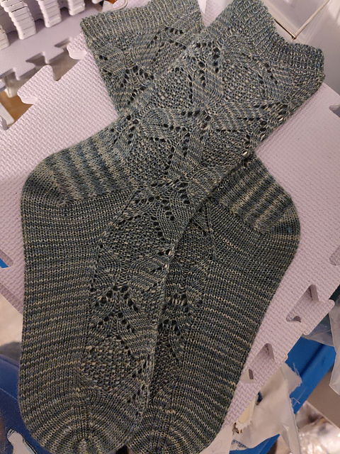 Mottled forest-green socks! The pattern is lace leaf-like motifs around a seed stitch center. It's supposed to mimic... thistles? Maybe? I'm not sure.